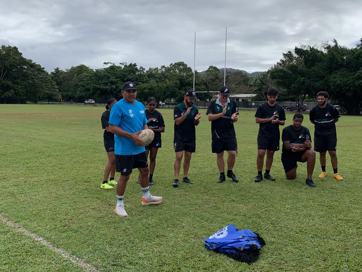 Matthew Bowen holding football demonstrating to students at a rugby league clinic