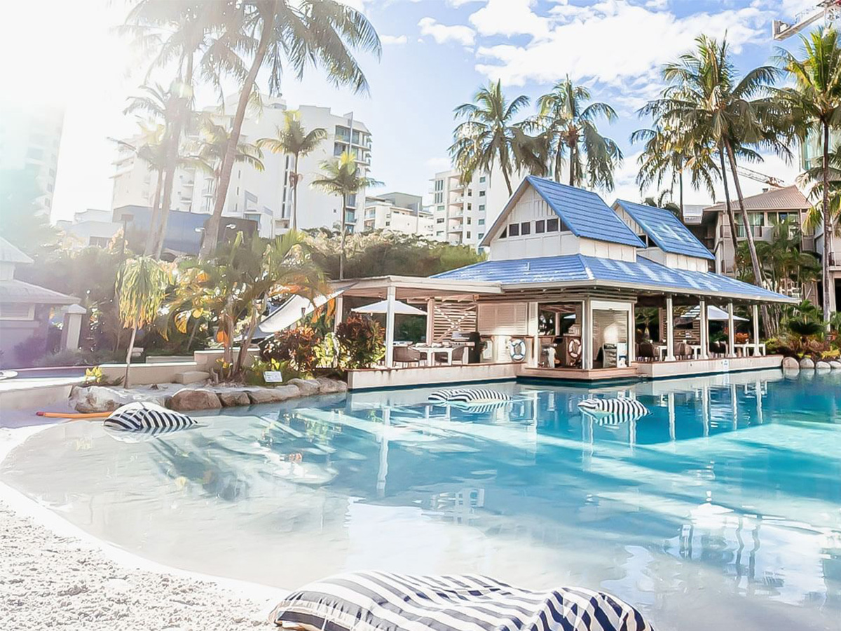 View of the Novotel Oasis pool capturing its inviting blue waters surrounded by lush greenery