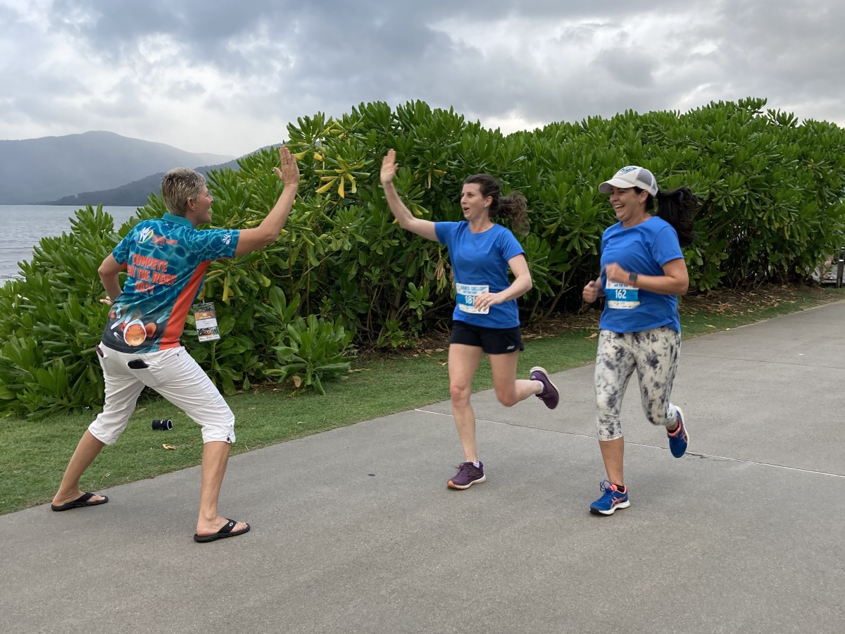 Pair of females running in fun run and receiving a hi-five