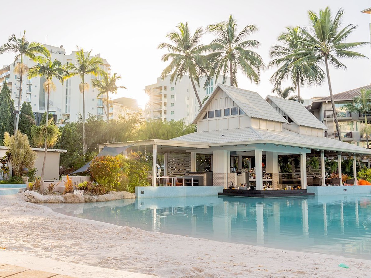 View of the Novotel Oasis pool capturing its inviting blue waters surrounded by lush greenery