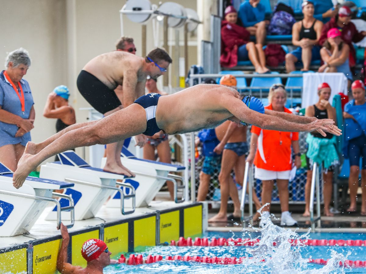Male masters swimmer diving into the pool