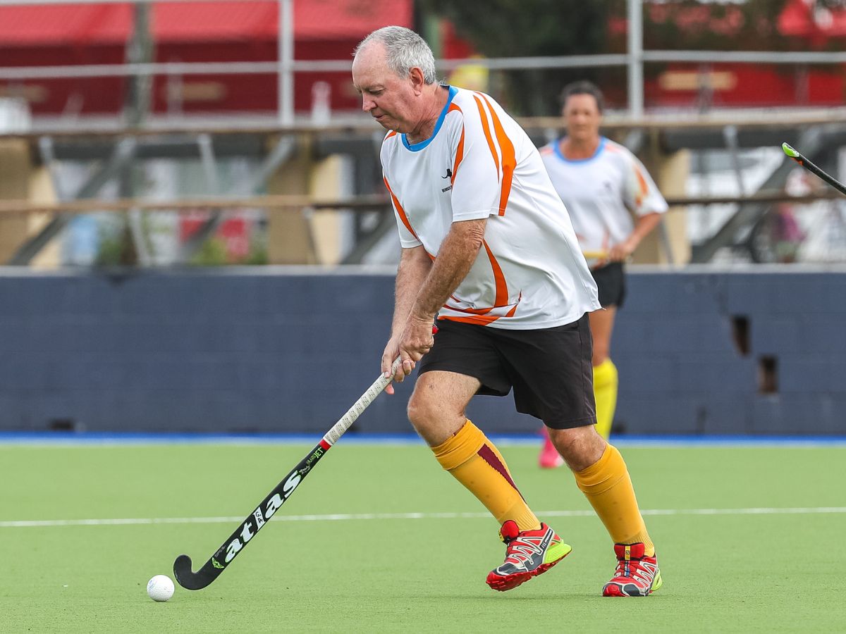 Masters man hitting hockey ball