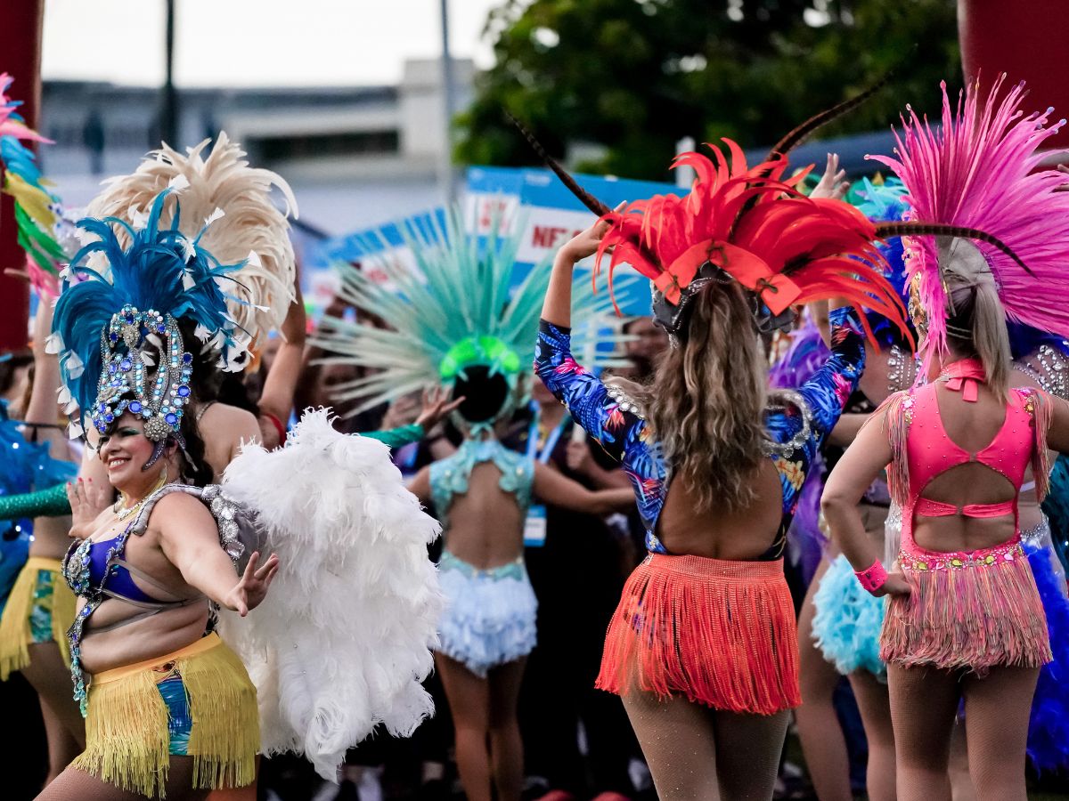 Salsa dancers wearing vibrant colours and feathered headpieces