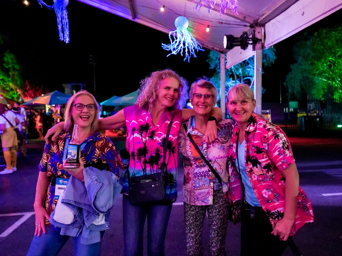 Group of competitors posing for a photo wearing tropical shirts